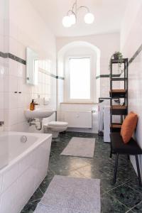a bathroom with a tub and a toilet and a sink at Stilvolles Apartment direkt am Marktplatz / Netflix und WiFi in Frankenberg