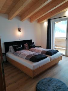 1 Schlafzimmer mit 2 Betten und einem großen Fenster in der Unterkunft Apart Alpenflair in Umhausen