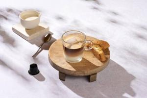 a glass of coffee and a banana on a wooden tray at villa in Agios Nikolaos Anavyssos in Áyios Yeóryios