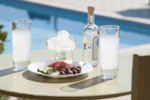 a table with a plate of food and glasses of milk at villa in Agios Nikolaos Anavyssos in Áyios Yeóryios