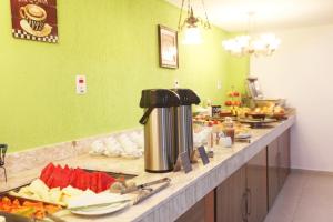 a buffet line with food on a counter in a restaurant at Hotel Perez in Pouso Alegre