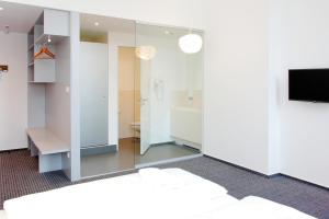 a room with a bathroom with a toilet and a tv at Maverick Budapest Soho in Budapest