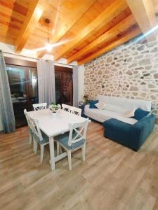 sala de estar con mesa, sofá y cama en CASA RURAL LA TORRITA, en Acebo