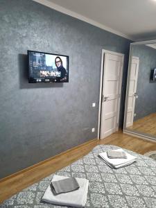 a room with a flat screen tv on a wall at Lily Central Apartment with free parking in Târgu-Mureş