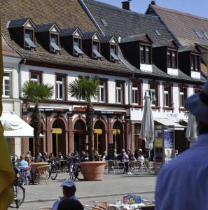 a group of people sitting at tables in front of a building at Maximilian in Speyer