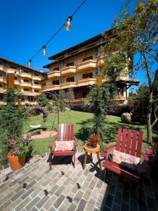 two chairs and a table in front of a building at Pousada Vovó Carolina in Gramado