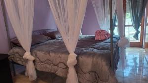 Un dormitorio con una cama con cortinas. en I Love Margò, en Torre a Mare