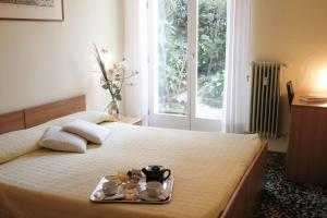 a bedroom with a bed with a tray of food on it at Hotel Santa Lucia in Venice
