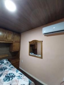 1 dormitorio con cama y espejo en la pared en CASA DE TOTAL DESCANSO Y SEGURIDAD, en Atlántida