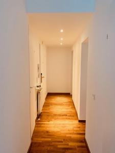 einen leeren Flur eines Apartments mit Holzboden in der Unterkunft Aurellia Deluxe Apartments in Wien