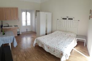 a bedroom with a white bed and a wooden floor at La Casa del Dottore in Rapolla