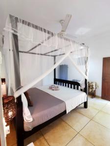 a bedroom with a bed with a canopy at Blue skies guest house and restaurant in Tangalle