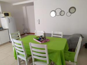 mesa de comedor verde con sillas blancas y mesa verde en Departamento el descanso en Olavarría