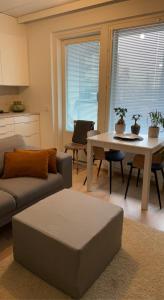 ein Wohnzimmer mit einem Sofa und einem Tisch in der Unterkunft MODERNI YKSIÖ HUIPPUSIJAINNILLA! in Lempäälä