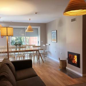 uma sala de estar com um sofá e uma lareira em Casa dos Pinheiros 109 - Private Villa with pool & heated SPA no Porto