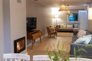 a living room with a couch and a fireplace at Casa dos Pinheiros 109 - Private Villa with pool & heated SPA in Porto