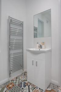 a white bathroom with a sink and a mirror at Central Avenue Apartment in Belfast