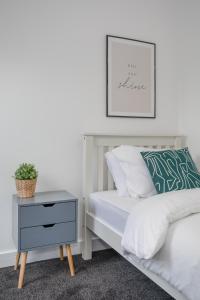 a bedroom with a bed with a nightstand and a picture at Central Avenue Apartment in Belfast