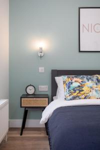a bedroom with a bed and a clock on a night stand at Central Avenue Apartment in Belfast