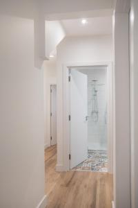 a hallway with white walls and wood floors and a bathroom at Central Avenue Apartment in Belfast