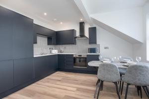 a kitchen and dining room with a table and chairs at Central Avenue Apartment in Belfast