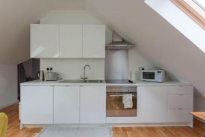 a white kitchen with a sink and a microwave at Plockton Sea View Apartment in Plockton