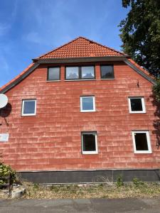 a red house with windows on the side of it at Zwei Eichen Gadenstedt in Ilsede