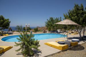 a swimming pool with yellow lounge chairs and an umbrella at Goknar Knidos Nature Hotel and Farm in Datca