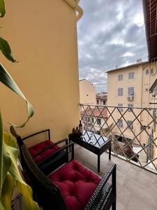 a balcony with two chairs and a table at Casa Nanà in Florence