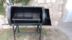 a barbecue grill sitting next to a stone wall at Bella Vista in Valle Hermoso