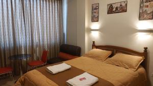 1 dormitorio con 1 cama, mesa y sillas en Hotel Los Andes del Sur en Potosí
