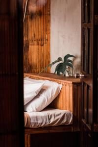 uma cama com uma cabeceira de madeira e um vaso de plantas em Casitas Stay and Surf em Baler