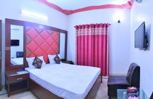 a bedroom with a large bed and a red curtain at Subhan Palace Guest House in Karachi