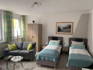 ein Wohnzimmer mit 2 Betten und einem Sofa in der Unterkunft Ferienwohnungen Marita in Salzwedel