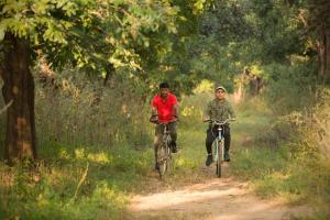 dos hombres montando bicicletas en un camino de tierra en Rukhad Jungle Camp - Pench, 