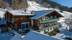 Una casa en la nieve con nieve en Appartement Ferienhof Ortnergut, en Eben im Pongau