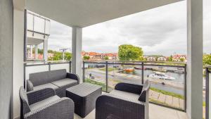 a balcony with two chairs and a view of a river at Apartamenty Sun & Snow Port Krynica in Krynica Morska