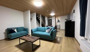 a living room with two blue chairs and a table at Furano Yukisachi House in Furano