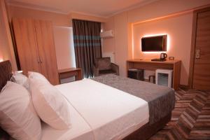 a hotel room with a bed and a television at Hotel Kale 17 in Çanakkale
