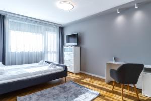 een slaapkamer met een bed, een bureau en een stoel bij Cosy 1BD Flat with a Lovely Balcony in Sofia