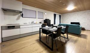 a kitchen and dining room with a table and a couch at Furano Yukisachi House in Furano