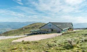 a building on top of a hill in a field at The Base Camp Hotel, Nevis Range in Fort William