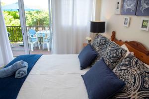 a bedroom with a large bed with blue pillows at Rothesay in Knysna