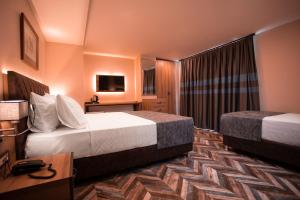 ein Hotelzimmer mit 2 Betten und einem TV in der Unterkunft Hotel Kale 17 in Canakkale