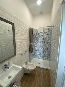 biała łazienka z umywalką i prysznicem w obiekcie Casaletto's Suites w mieście Riano