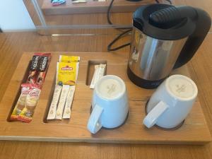 a wooden tray with a coffee pot and two mugs at Basoglu Bulancak Hotel in Bulancak