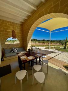 Habitación con mesa, sillas y sombrilla en masseria a libeccio, en Maruggio