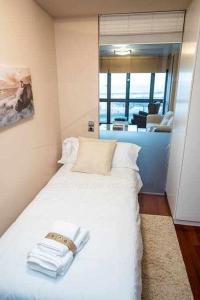 ヒホンにあるBahia Apartamentoのベッドルーム1室(財布付きの白いベッド1台付)