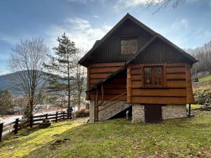 eine kleine Holzhütte auf einem Hügel mit einem Zaun in der Unterkunft Domek na Cuplu - opcjonalnie balia jacuzzi in Szczyrk