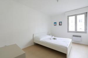 um quarto branco com uma cama e uma janela em Spacious and calm apartment in Montrouge - Welkeys em Montrouge